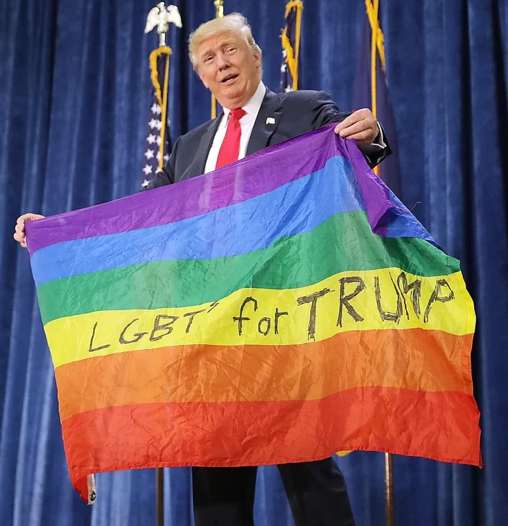 Donald Trump holding an LGBT for Trump flag