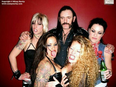 Lemmy posing with porn stars and groupies