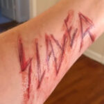 Slayer carved into skin