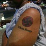 A Black man with Nazi Swastika and White Power tattoos